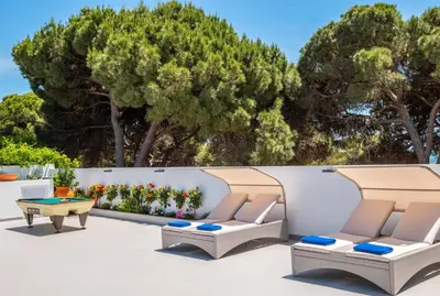 a patio with chairs and a table and trees at Villa Sequeira in Albufeira