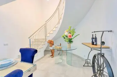 a dining room with a glass table and stairs at Villa Sequeira in Albufeira