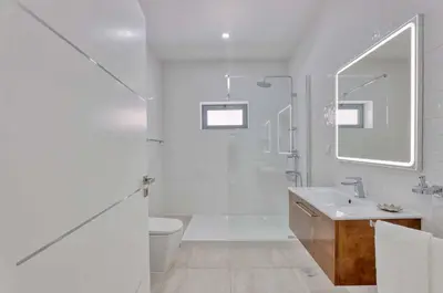 a white bathroom with a sink and a toilet at Villa Sequeira in Albufeira