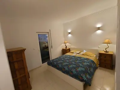 a bedroom with a bed and a large mirror at Apartamento Mimosas in Albufeira
