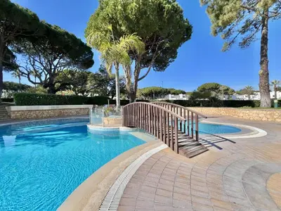a swimming pool with a wooden fence and trees at Albufeira Balaia Golf Vilage 1 With Pool by Homing in Albufeira