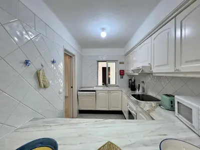 a kitchen with white cabinets and a sink at Albufeira Balaia Golf Vilage 1 With Pool by Homing in Albufeira