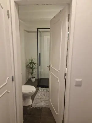 a bathroom with a toilet and a door open at Apartamento em Quarteira in Quarteira