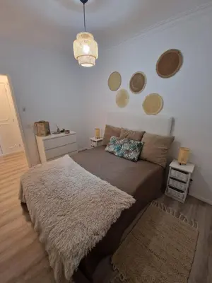 a bedroom with a large bed with a rug at Apartamento em Quarteira in Quarteira