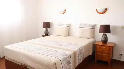 a bedroom with a bed with two lamps on a night stand at Visconde By Albufeira Rental in Albufeira