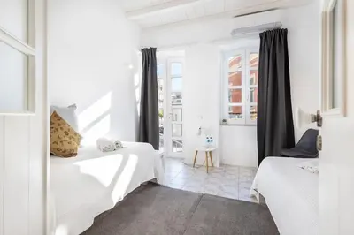 a white room with two beds and a window at RG Casa do Carmo in Faro