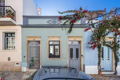 a blue house with a car parked in front of it at RG Casa do Carmo in Faro