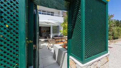 a green fence in front of a house at Keiko in Vale do Lobo