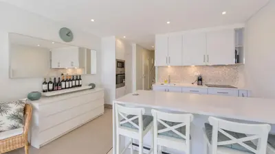 a kitchen with white cabinets and a large white island at Keiko in Vale do Lobo