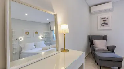 a mirror in a room with a couch and a chair at Keiko in Vale do Lobo