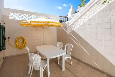 a table and chairs and an umbrella on a patio at Private 2 Bed Apartment in Albufeira Old Town in Albufeira