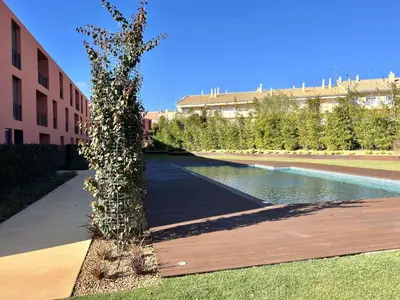 a tree in the middle of a sidewalk next to a building at One - Luxurious apartment by HD PROPERTIES in Vilamoura