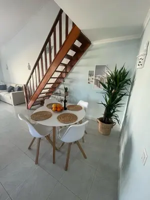 a dining room with a table and chairs and a staircase at casa Vela in Albufeira