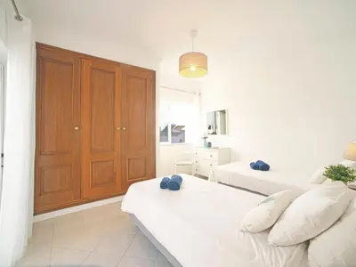 a bedroom with two beds and a wooden cabinet at Villa Inês by Interhome in Galé
