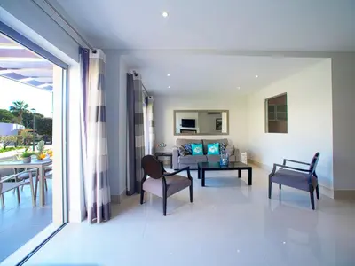 a kitchen with white cabinets and a dining room at Apartment Pine Hills Ametista by Interhome in Vilamoura