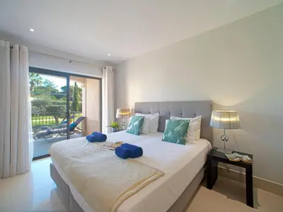 a large pool with palm trees in front of a building at Apartment Pine Hills Pérola by Interhome in Vilamoura