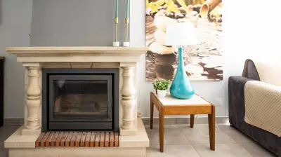 a living room with a fireplace and a blue vase on a table at Casa da Praia - São Rafael - BY BEDZY in Albufeira