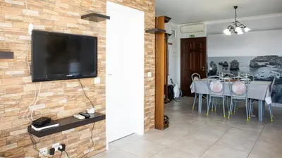 a living room with a television on a brick wall at Casa da Praia - São Rafael - BY BEDZY in Albufeira