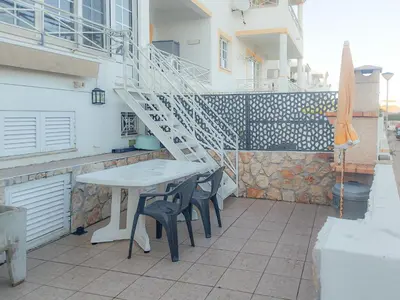 a white table and chairs on a patio with a staircase at Casa da Praia - São Rafael - BY BEDZY in Albufeira