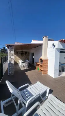 a pair of lounge chairs on a deck with a building at Oura Villa V2 Jacarandá in Albufeira