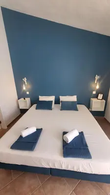 a large white bed with two blue pillows on it at Oura Villa V2 Jacarandá in Albufeira