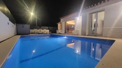a swimming pool at night in a house at Oura Villa V2 Jacarandá in Albufeira