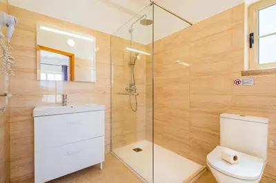 a bathroom with a toilet and a glass shower at Villa Duarte in Albufeira