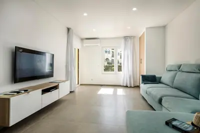 a living room with a couch and a flat screen tv at Oura Sunset Apartement in Albufeira
