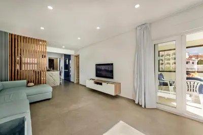 a living room with a blue couch and a television at Oura Sunset Apartement in Albufeira