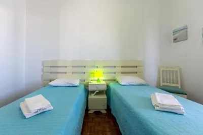 a bedroom with two beds and a night stand with a lamp at T3 Apartamento do Tenis in Albufeira