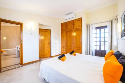 a bedroom with a large white bed with yellow pillows at Villa Molucas by Algarve Vacation in Albufeira