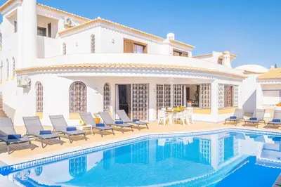 a villa with a swimming pool in front of a house at Villa Molucas by Algarve Vacation in Albufeira