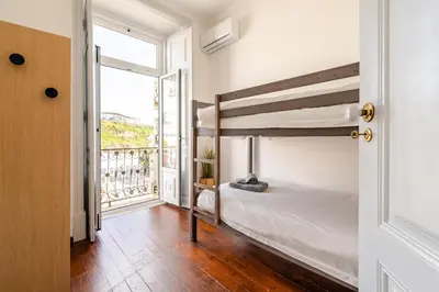 a bedroom with a bunk bed and a balcony at Down Town Beach House in Albufeira
