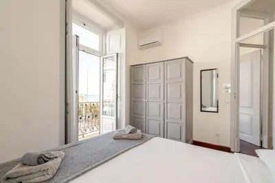 a white bedroom with a large bed with towels on it at Down Town Beach House in Albufeira