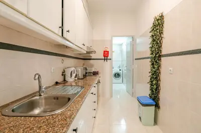 a kitchen with a sink and a washing machine at Down Town Beach House in Albufeira