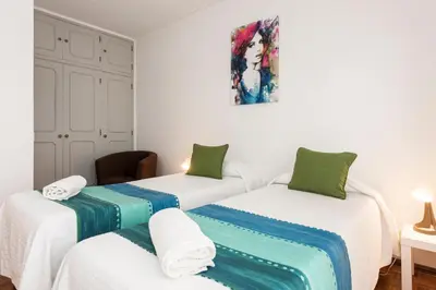 two twin beds in a room with white walls at OLIVE - Quarteira in Quarteira