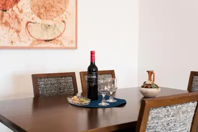 a bottle of wine and glasses on a wooden table at OLIVE - Quarteira in Quarteira