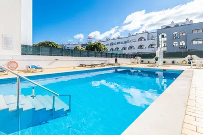 a pool at a hotel with blue water at Beautifull CentralApart W/pool in Albufeira