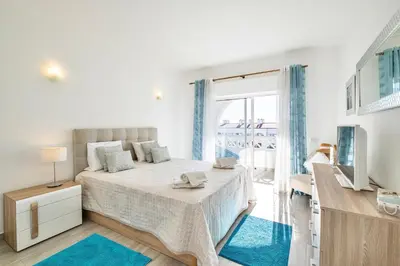 a white bedroom with a bed and a window at Beautifull CentralApart W/pool in Albufeira