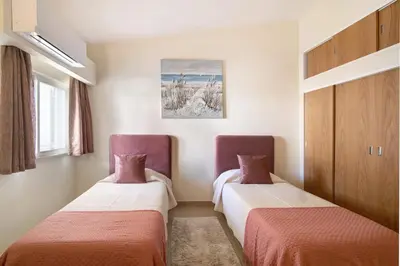 two beds in a room with red and white at Villa Nicola in Vale do Lobo