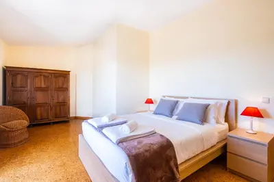 a bedroom with a large bed and a wooden cabinet at Villa Estrelícia - Pool - Free wi-fi - New in Booking in Loulé