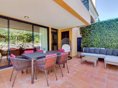 a patio with a table and chairs and a couch at AL - Apartamento Vila Sol F5 AO in Vilamoura