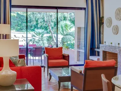 a living room with red chairs and a fireplace at AL - Apartamento Vila Sol F5 AO in Vilamoura