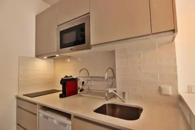 a kitchen with a sink and a microwave at Quarteira Mar - Beach Front in Quarteira