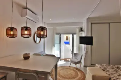 a living room with a table and chairs and lights at Quarteira Mar - Beach Front in Quarteira