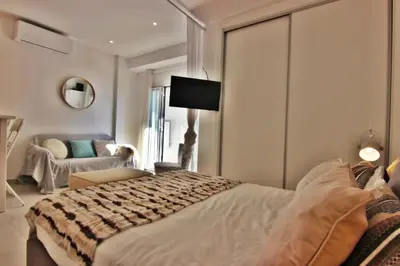 a bedroom with a large bed and a living room at Quarteira Mar - Beach Front in Quarteira