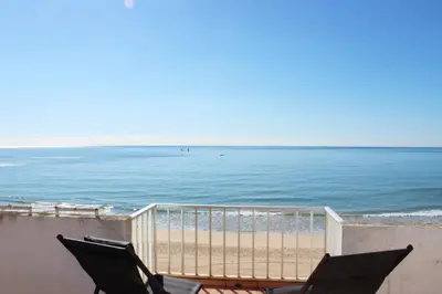 a view of the beach from a balcony with two chairs at Quarteira Mar - Beach Front in Quarteira