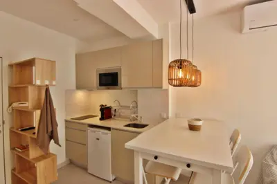 a kitchen with white cabinets and a table with chairs at Quarteira Mar - Beach Front in Quarteira