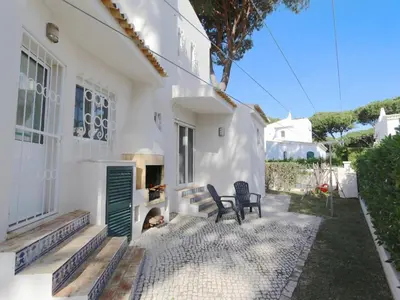 a white house with two chairs and a fireplace at Lovely Vilamoura Villa 4 Bedrooms Villa Pinhal Short Drive To Marina in Quarteira