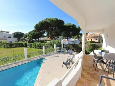 a villa with a swimming pool and a table and chairs at Lovely Vilamoura Villa 4 Bedrooms Villa Pinhal Short Drive To Marina in Quarteira